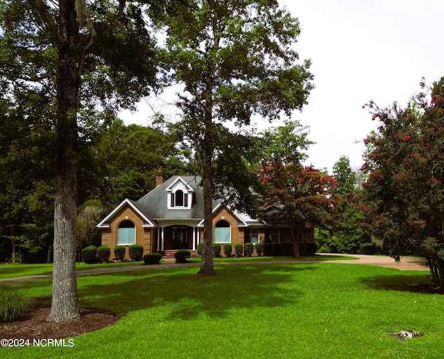 cape cod-style house featuring a front yard