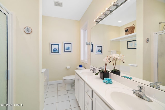 bathroom featuring tile patterned flooring, vanity, a shower with shower door, and toilet