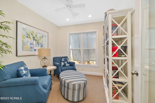 sitting room with ceiling fan and carpet flooring