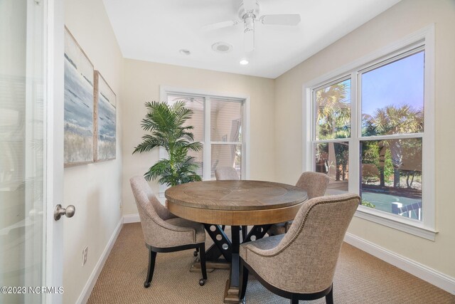 dining area featuring light carpet and ceiling fan