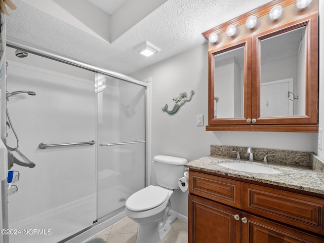 bathroom featuring tile patterned floors, vanity, a shower with door, and a textured ceiling