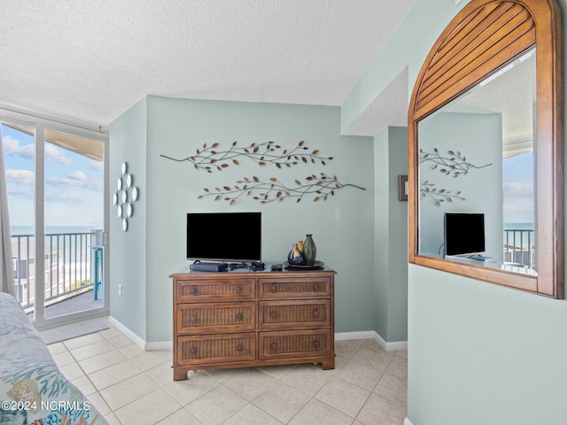 living room featuring plenty of natural light, light tile patterned floors, and a textured ceiling