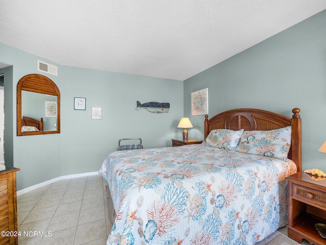 bedroom featuring light tile patterned flooring and a textured ceiling