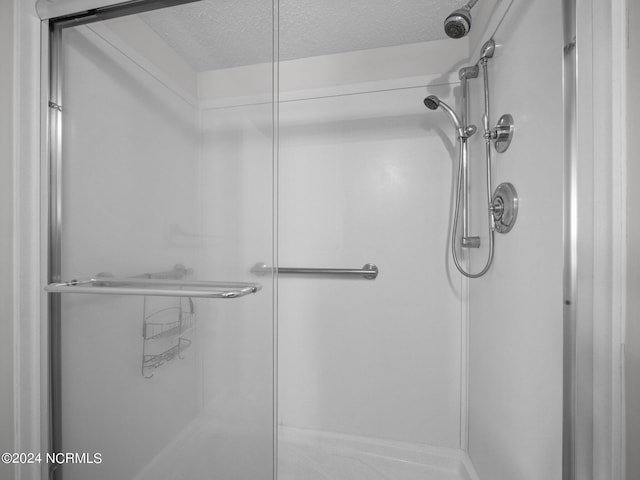 bathroom with a textured ceiling and walk in shower