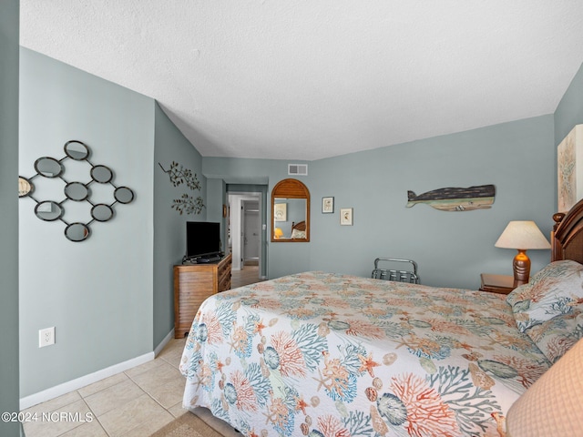 tiled bedroom featuring a textured ceiling