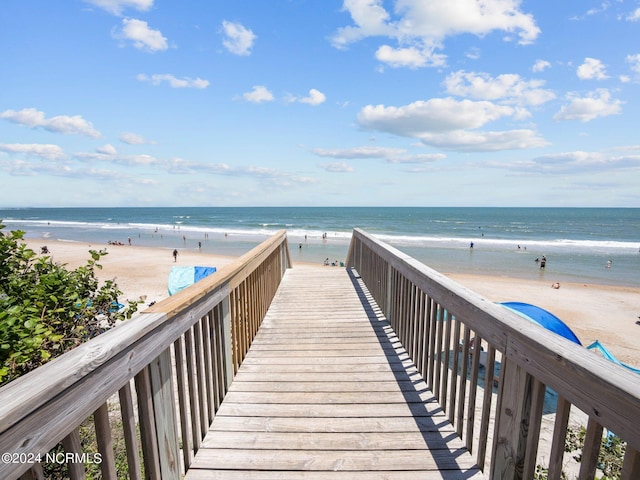 view of property's community featuring a water view and a beach view