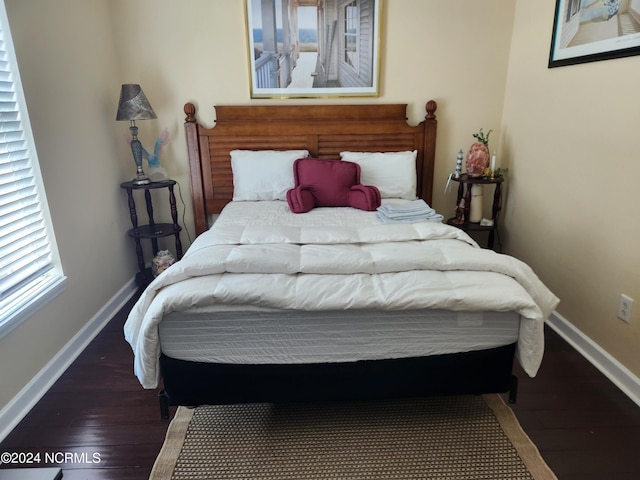 bedroom with wood finished floors and baseboards