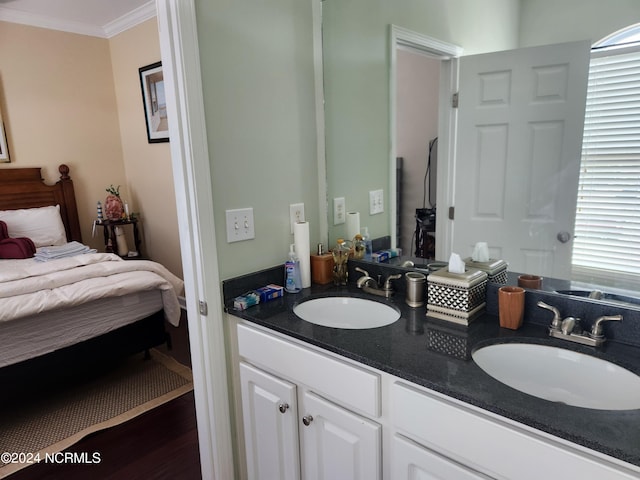 full bath with double vanity, ornamental molding, a sink, and wood finished floors