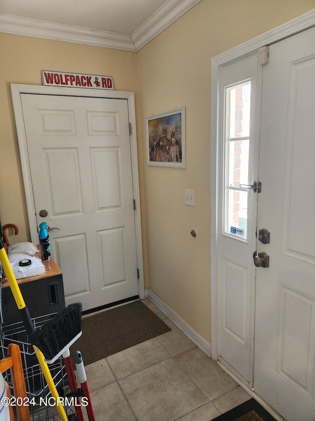 doorway featuring light tile patterned floors, ornamental molding, and baseboards