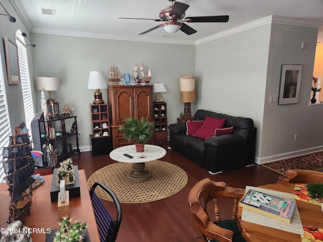 living area with ornamental molding, wood finished floors, visible vents, and baseboards