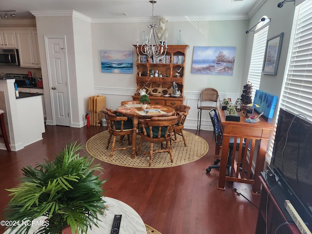 dining room with dark wood-style floors, ornamental molding, a notable chandelier, and wainscoting