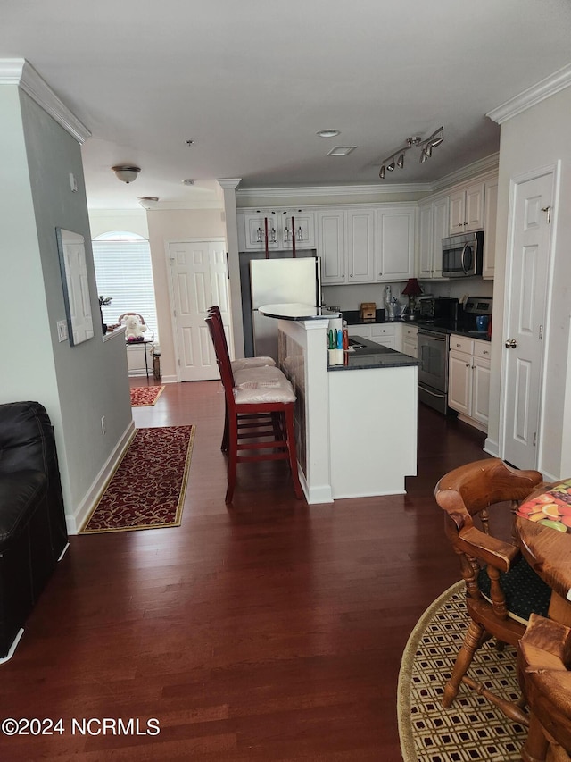 kitchen with ornamental molding, appliances with stainless steel finishes, dark wood finished floors, and a center island