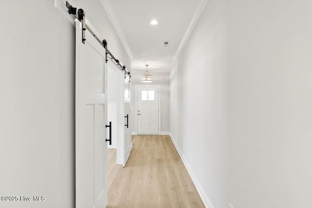 entryway with a chandelier, ornamental molding, and light wood-type flooring