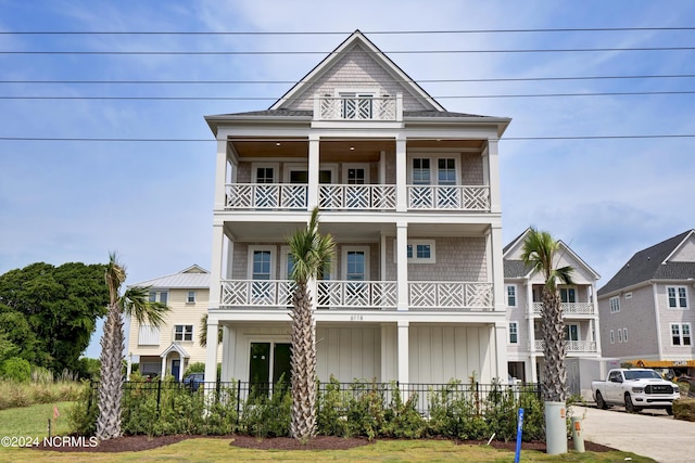 view of front of home with a balcony, fence, and board and batten siding