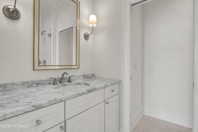 full bath with vanity, baseboards, and walk in shower