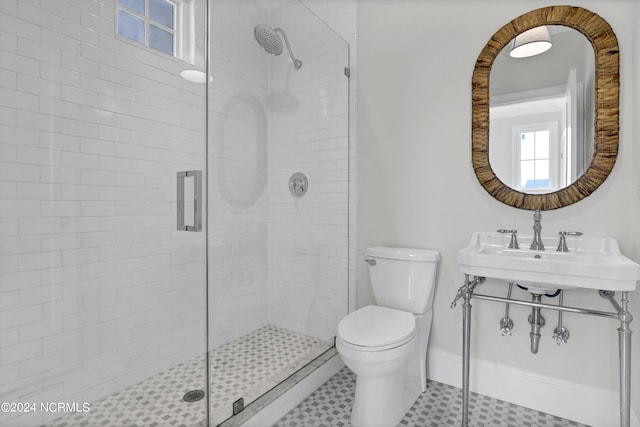 bathroom featuring a sink, toilet, and a shower stall