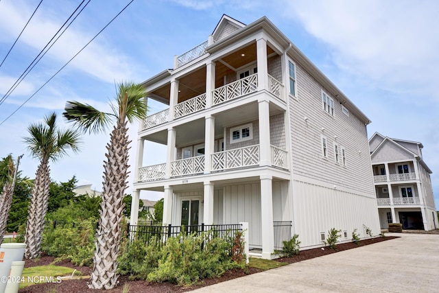 exterior space with a porch, board and batten siding, and a balcony