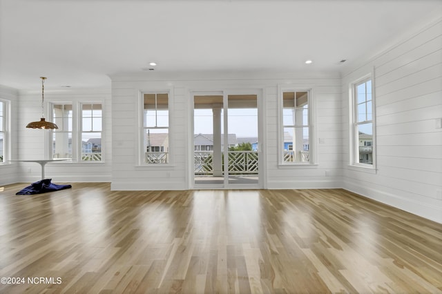 unfurnished living room with a wealth of natural light, baseboards, wood finished floors, and recessed lighting