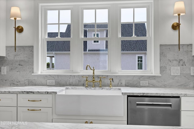 kitchen featuring a sink, stainless steel dishwasher, a wealth of natural light, and white cabinetry