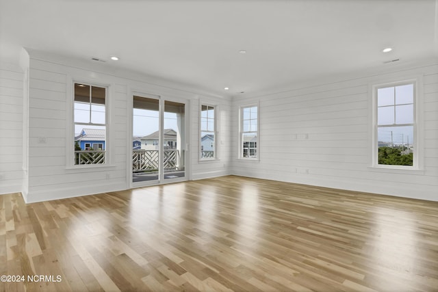 unfurnished living room featuring recessed lighting, wood finished floors, visible vents, and a healthy amount of sunlight