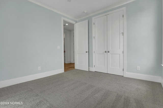 unfurnished bedroom with carpet, baseboards, and a closet