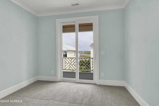 carpeted spare room featuring visible vents, crown molding, and baseboards