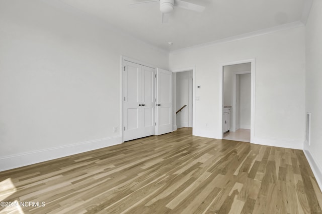 unfurnished bedroom featuring ceiling fan, light wood-style flooring, baseboards, and ornamental molding