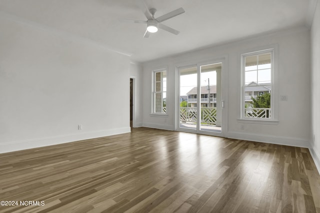 empty room featuring a ceiling fan, wood finished floors, and baseboards