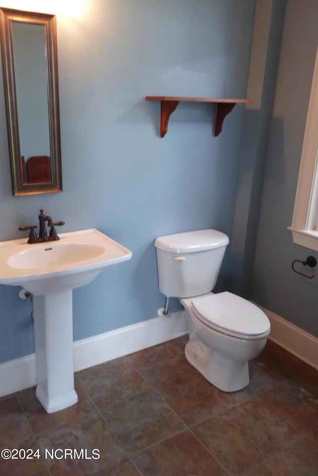 bathroom featuring toilet and baseboards