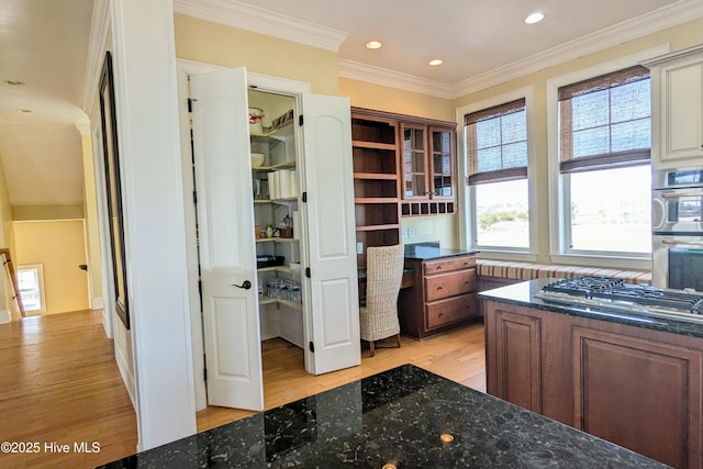 interior space with light wood-type flooring, crown molding, built in desk, and recessed lighting