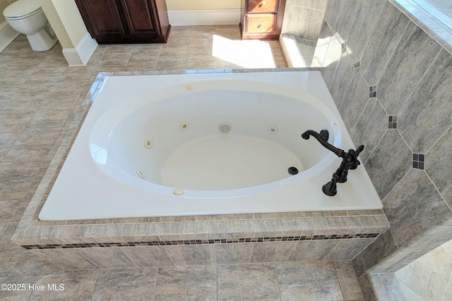 bathroom featuring a jetted tub and toilet