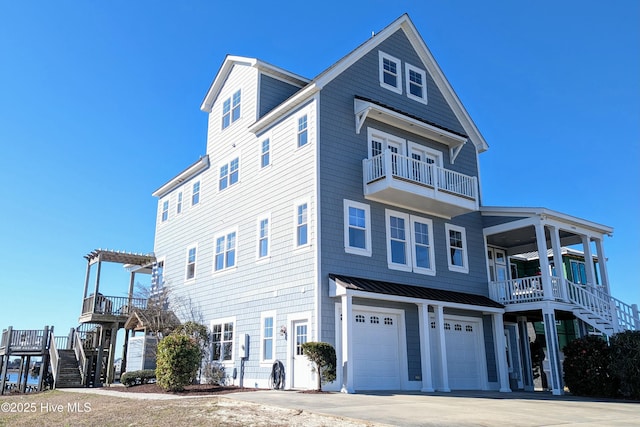 view of front of property with an attached garage, a standing seam roof, stairway, and metal roof