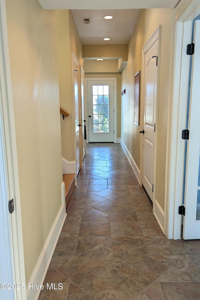 doorway to outside featuring baseboards, visible vents, and recessed lighting