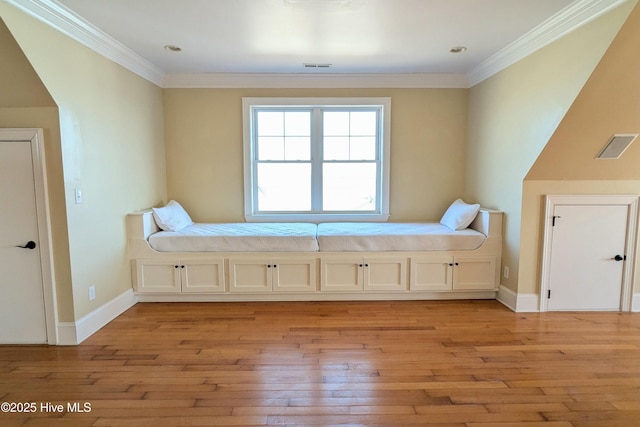 unfurnished bedroom with light wood-style floors, visible vents, baseboards, and crown molding