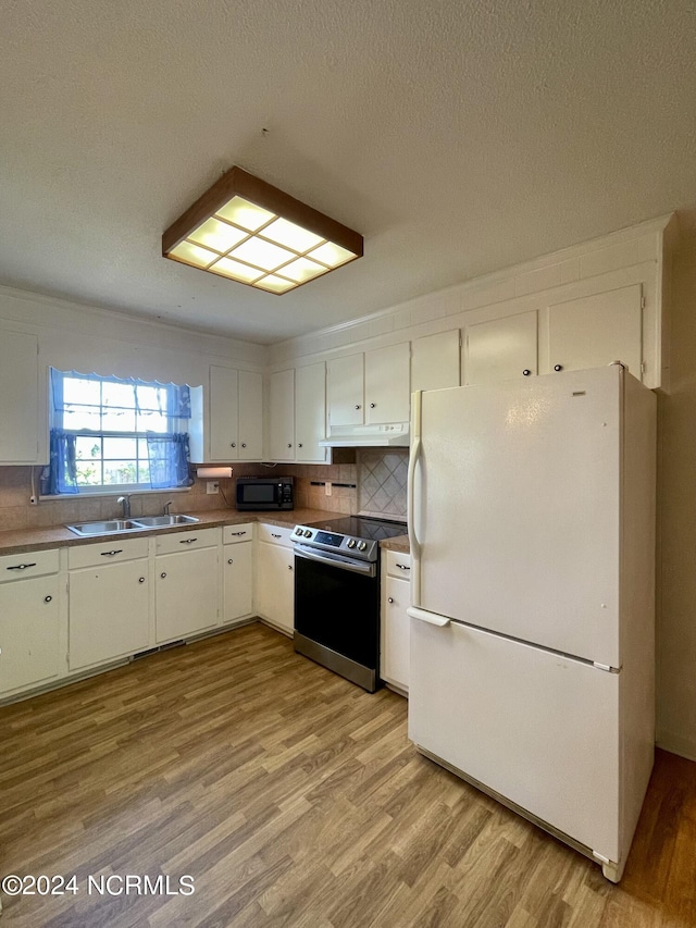 kitchen featuring freestanding refrigerator, stainless steel electric range, under cabinet range hood, black microwave, and a sink