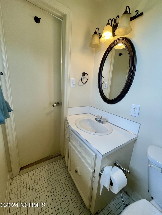 half bathroom with vanity and toilet