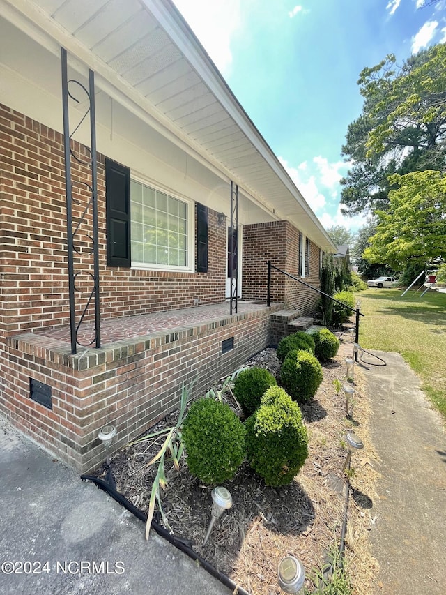 view of side of property with crawl space and brick siding