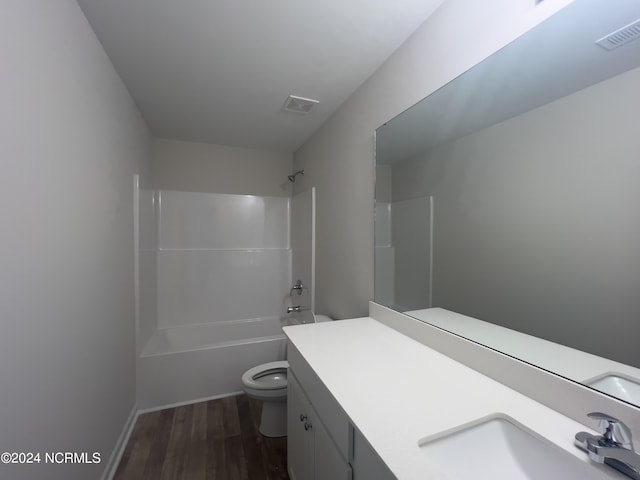 full bathroom with wood-type flooring, bathing tub / shower combination, vanity, and toilet