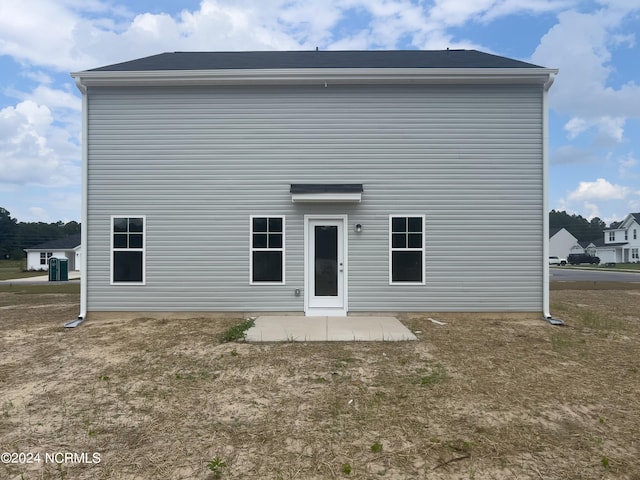 back of property featuring a patio area and a yard