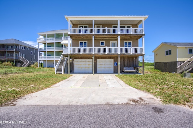 view of front of home featuring a balcony, a garage, and a front lawn