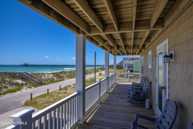 deck featuring a beach view and a water view