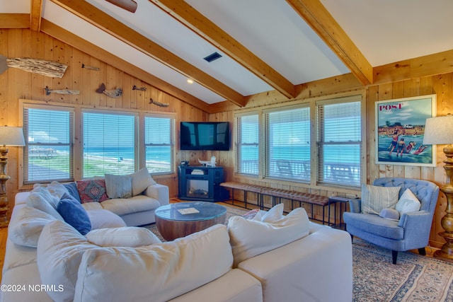 living room with lofted ceiling with beams and wood walls