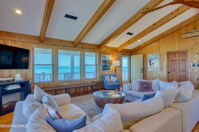 living room with vaulted ceiling with beams and wooden walls