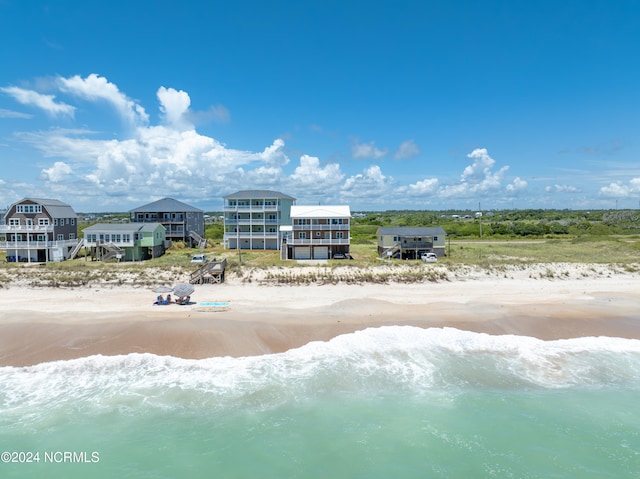 birds eye view of property with a water view and a view of the beach