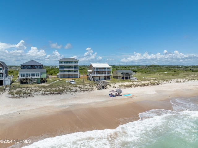 drone / aerial view with a water view and a beach view