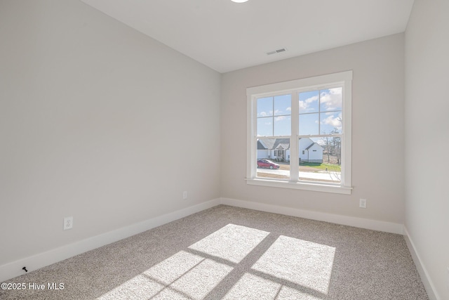 spare room featuring light colored carpet