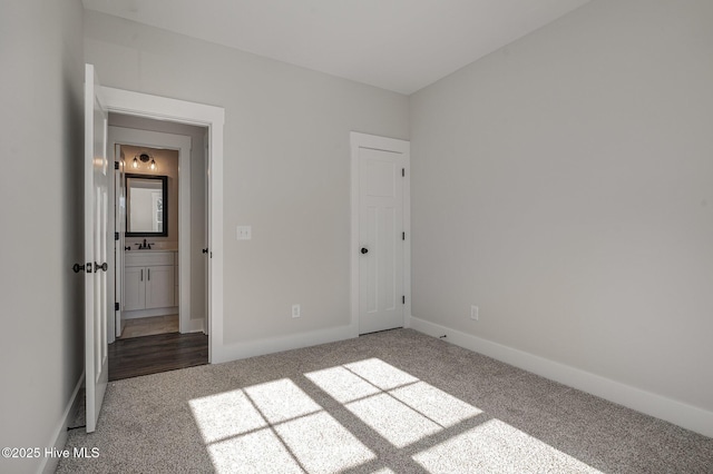 unfurnished bedroom with sink and carpet floors