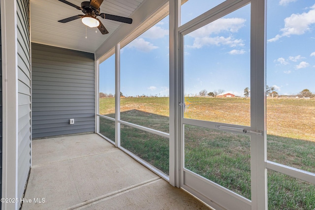 unfurnished sunroom with ceiling fan