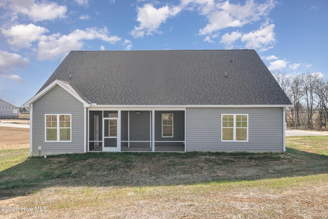 rear view of property with a lawn and a sunroom