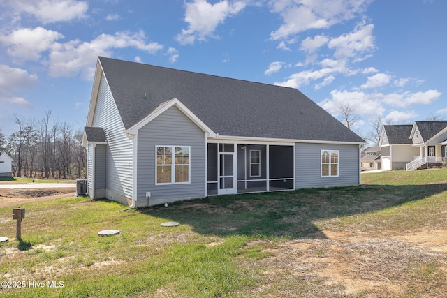 rear view of property with a sunroom, central AC unit, and a lawn